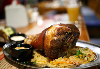 juicy fried pork knuckle on a platter with stewed cabbage