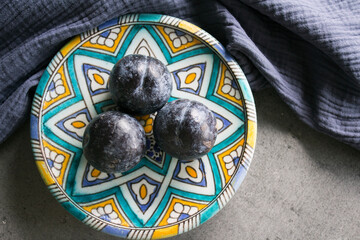 Fresh plums on beautiful authentic plate. Top view photo of fresh fruits. 