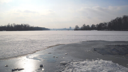 Nature photo winter. Frozen river, blue sky, sun in the sky, ice.