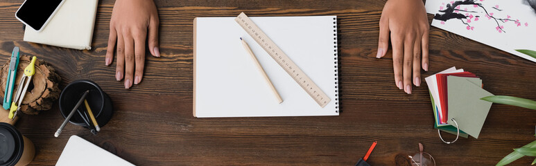 top view of hands of interior designer near sketchbook, pencil and ruler on desk, banner