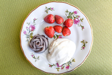 .Summer dinner, strawberries and cream on the plate.