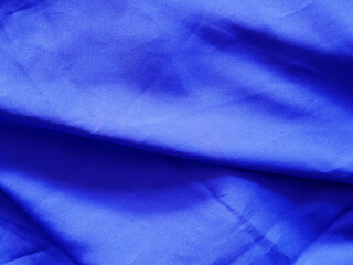 Smooth elegant dark blue silk textured background. Copy space.