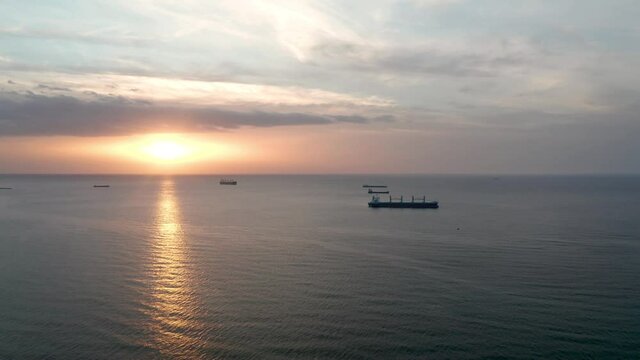 A drone flight around container ships into the sea at sunrise, the Black Sea, Bulgaria