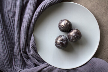 Plums on grey plate. Top view photo of fresh garden fruits. Simple still life. 