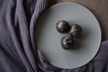 Plums on grey plate. Top view photo of fresh garden fruits. Simple still life. 