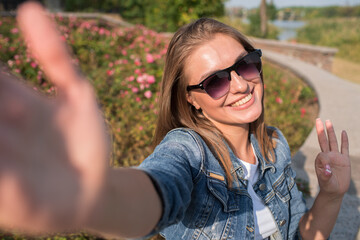 Pretty blonde girl makes selfie on smartphone