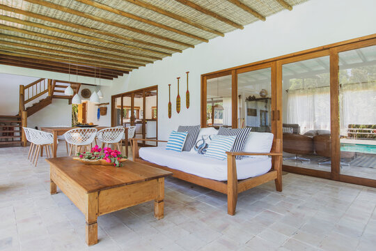 Modern summer holiday or vacation wooden beach house interior with rustic luxury sofas, tables and decoration. 