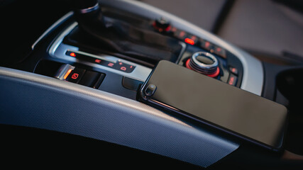 Fototapeta na wymiar Smartphone on the modern car interior.