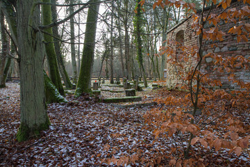 Ruins of an Old abandoned church and churchyard in a forest. In winter.
