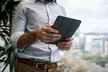 Man working with tablet next to window