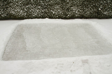 Backyard Ice-skating Rink created on a lawn in winter