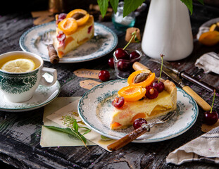 homemade two tasty slices of cottage cheese pie or cheesecake with apricots and cherries on top. selective focus