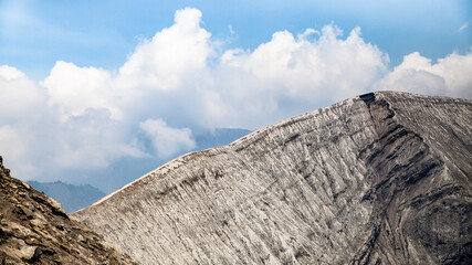 Beautiful mountain landscape. Part of the crater of the Bromo volcano. View from the top of the mountain. Blue sky and frozen lava.