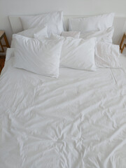 bed made with white linens in the hotel