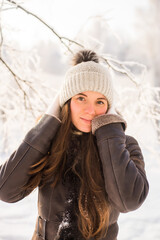 Portrait of young beautiful woman in winter clothes and strong snowing.