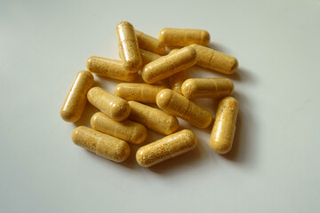 Heap of orange cellulose capsules of multivitamins
