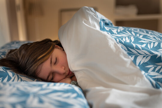 toddler spleeping in her bed, young girl dreaming peacefully up to late morning, opportunity to restore on holiday and vacation, snuggling in to the warm blanket