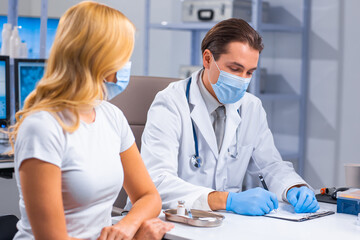 Professional doctor makes a coronavirus vaccine using a syringe and hypodermic needle. Professional medical worker and patient at the hospital office. Vaccination and safety.