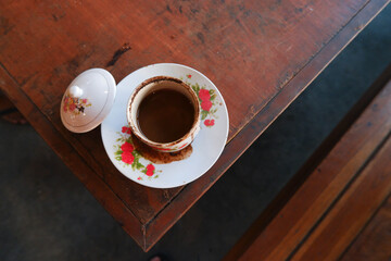 Traditional coffee in a cup on a wooden table. half coffee 