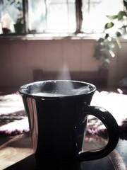 cup of coffee on the table under the morning sun 