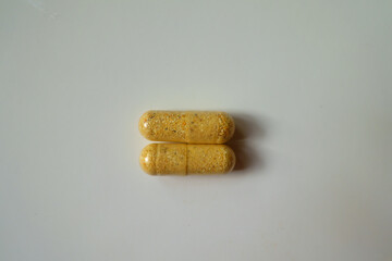 Identical two orange cellulose capsules of multivitamins from above