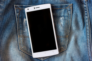 white smartphone on blue frayed jeans background hipster modern lifestyle mock up to insert text	
