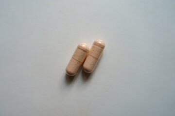 View of two pink capsules of probiotic dietary supplement from above