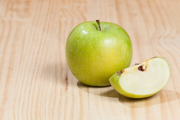 Tasty green apple; photo on wooden background.