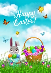 Easter bunny with egg hunt basket in grass vector design. Rabbit with Easter egg bucket sitting on spring field of green grass blades and flowers, crocuses, pansies, lilies of valley and butterflies