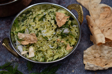 Vegan Indian dill rice and papad served in traditional hammered bowl