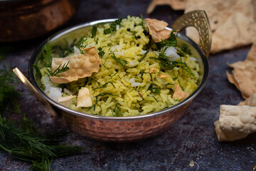 Vegan Indian dill rice and papad served in traditional hammered bowl