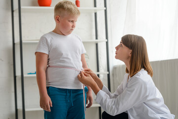 Little chubby boy being measured by a friendly doctor