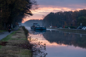 Cargo ship on a river during a misty sunrise morning. High quality photo