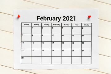 Calendar page on February 2021 on white wooden background.