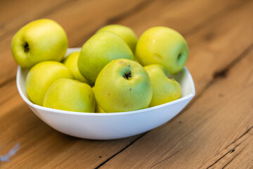 A bowl of fruit sitting on top of a wooden table