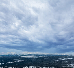 View over a majestic wilderness landscape in winter with dramatic storm clouds.