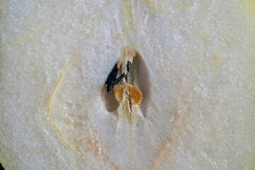 Fresh pear half. Cut pear on black background, macro