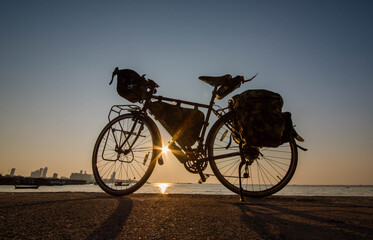 Fototapeta na wymiar Touring bike parked in the evening at Pattaya Beach, Thailand