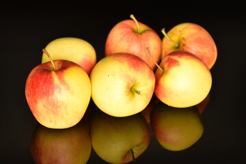 Several ripe organic, juicy, fragrant apples, close-up, on a black background.