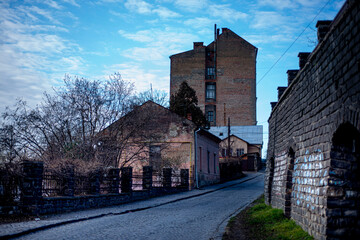 staninny town street, mystical cityscape, old paving stone in a European city, facades of stone houses