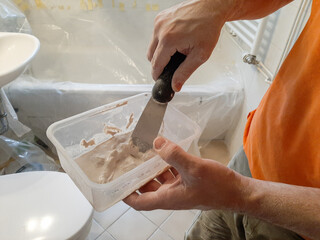 craftsman mixes the material for his work in a bathroom