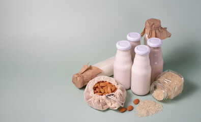 Obraz na płótnie Canvas a variety of lactose-free vegetarian milk from nuts and grains in glass bottles. light vegan concept with a milk drink made from hazelnuts, oats, coconut, almonds, walnuts, rice