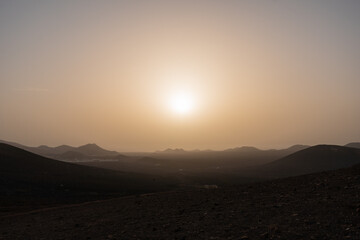 Sunset behind hazy volcanos of lanzarote