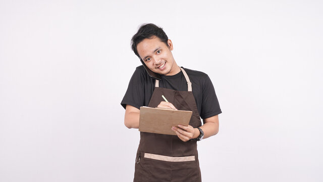 The man wearing the apron stands on a white background isolated on the menu list with phone