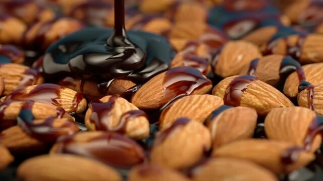 Slow motion almonds are poured with chocolate on a black background