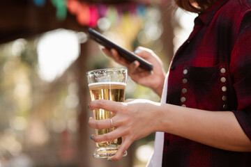 Happy Holidays Concept Male teenager playing smartphone with beer bottle
