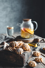 Tasty cakes with Hot tea with slices of fresh grapefruit on wooden tablet. Healthy drink, Eco, vegan