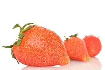 A group of many juicy strawberries, close-up, on a white background.