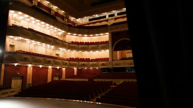 Opening view of the glowing concert hall of the theater from the backstage. Large concert hall. Backstage, curtains
