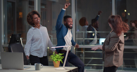 Excited multiracial business team dancing in office